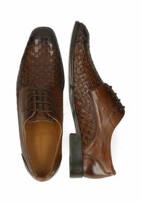 Chaussures en cuir marron présentant une texture tissée sur le bout et des côtés lisses, avec une forme ronde et un petit talon carré.