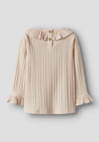 Lys rosa langermet topp med ribbet tekstur, rysjekrave og frynselement på ermene; har to tresnipper på baksiden.