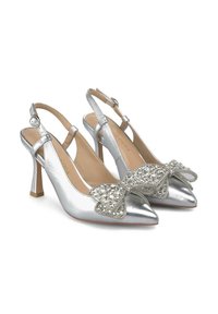 Chaussures à talons hauts en métal argenté avec un bout pointu, ornées d'un nœud décoratif incrusté de cristaux à l'avant.