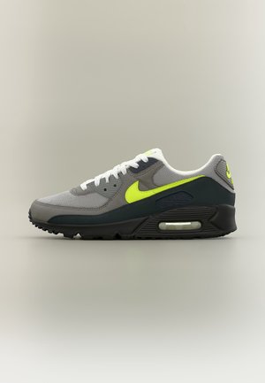Szaro-czarny sneaker Nike Air Max z neonowo-żółtym logo i akcentami, białymi sznurówkami oraz widoczną poduszką powietrzną w podeszwie.