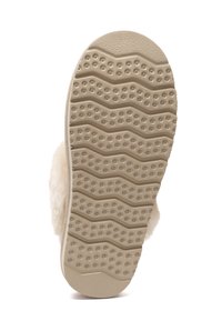 Beige, strukturierte Gummisohle mit Wellenmuster und runden Griffen. Der obere Teil besteht aus weichem, flauschigem Material.