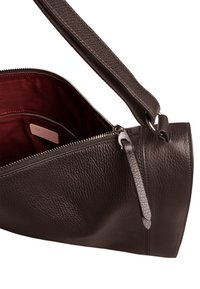 Borsa a mano in pelle marrone con finitura testurizzata, fodera interna rossa, chiusura con zip superiore e tracolla removibile.
