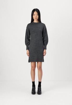 Robe en tricot grise avec un col rond et des manches longues bouffantes. L'ourlet est légèrement au-dessus des genoux, avec une finition côtelée.