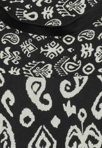 Schwarzer Stoff mit weißen abstrakten Mustern, der verschiedene Formen wie Wirbel und Diamanten zeigt, sowie eine strukturierte Oberfläche mit einem runden Ausschnitt.