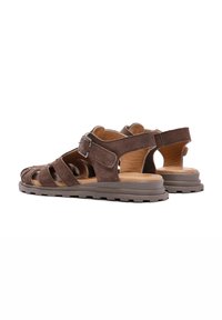Sandali in suede marrone con più cinghie, fibbia regolabile e suola imbottita con grip testurizzato per una maggiore stabilità.