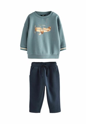 Lichtblauwe sweatshirt met vliegtuigborduring, ronde halslijn, ribgebreide manchetten; marineblauwe joggerpants met elastische tailleband en zijzakken.