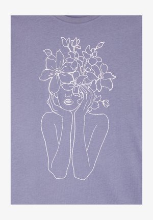 T-shirt lilla con design ricamato bianco raffigurante un volto con le mani sulle guance, ornato da elementi floreali sopra la testa.