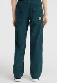 Petrolkleurige corduroy cargobroek met wijde pijpen, voorzien van twee zijzakken en een label op de rechter achterzak. Getextureerde stof, comfortabele pasvorm.