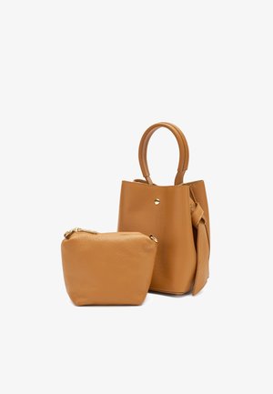 Piccola borsa a secchiello in pelle color beige con manico superiore e pochette coordinata con zip nella parte anteriore su sfondo bianco.
