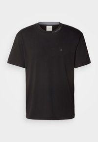 T-shirt nera girocollo realizzata in tessuto morbido. Caratterizzata da maniche corte e un piccolo logo "ck" sul davanti, vicino al petto.