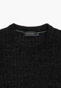 Maglione di lana nera con una superficie testurizzata e un collo a coste. Presenta un'etichetta verde all'interno con il testo "GIANNI LUPO".