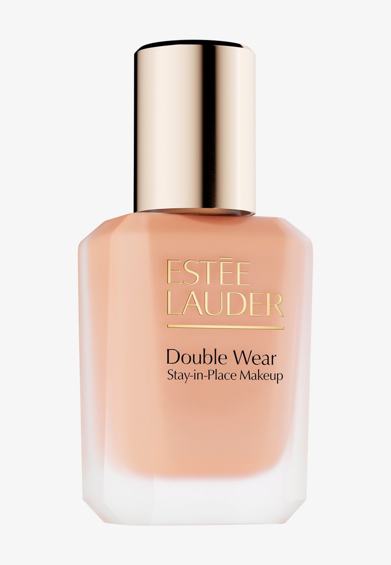 Fond de teint Estée Lauder Double Wear dans un flacon en verre givré, équipé d'un bouchon doré et d'une étiquette avec du texte noir. Liquide lisse de teinte pêche à l'intérieur.