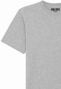 T-shirt gris à manches courtes en tissu doux, avec un col rond et une étiquette imprimée sur le col portant la marque "MIRA PARIS".