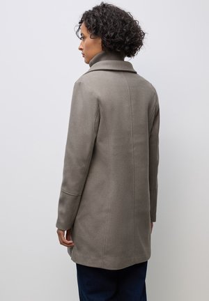 Abrigo de mezcla de lana gris con cuello alto, corte ajustado y mangas largas. Presenta líneas limpias y una textura suave, alcanzando una longitud a mitad del muslo.