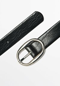 Zwarte leren riem met een gestructureerde afwerking, voorzien van een zilveren ronde riemgesp en één verstelgat. Glad en duurzaam materiaal.