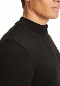 Maglione zip con collo alto di colore nero, caratterizzato da una trama a coste e un design aderente. Il materiale liscio conferisce un aspetto elegante.