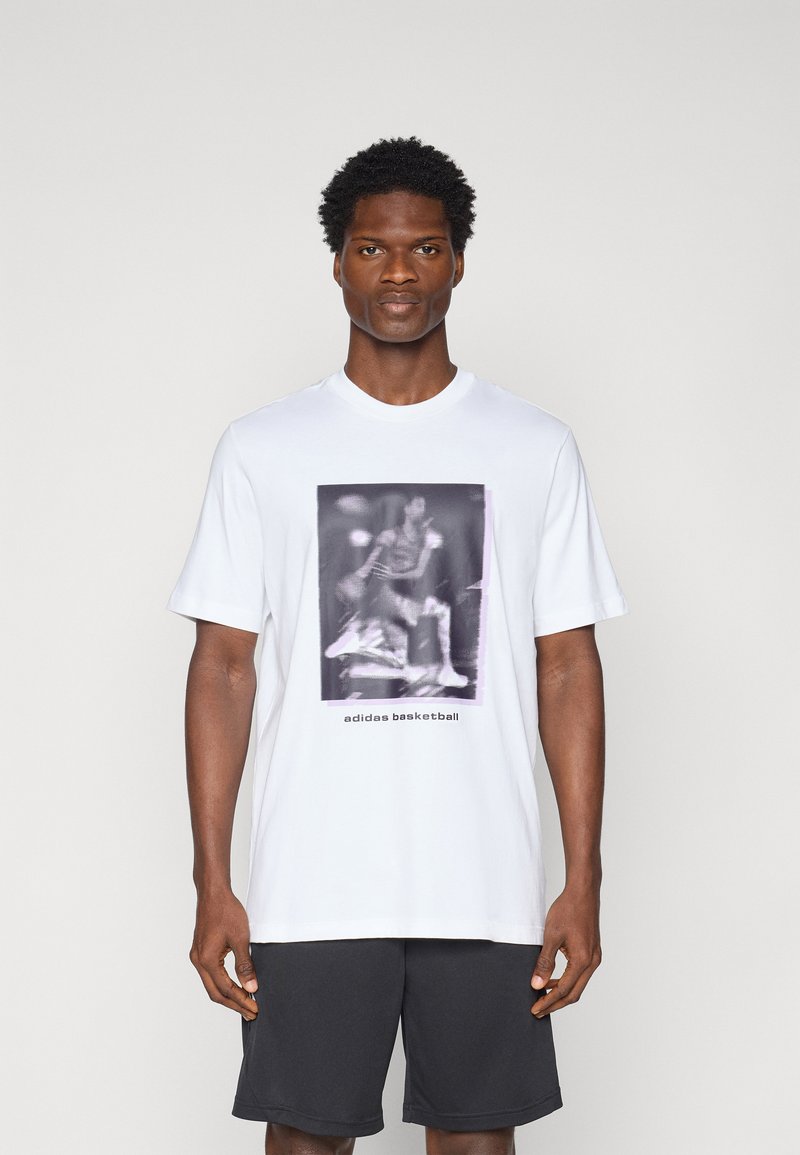White cotton t-shirt featuring a graphic in gray tones depicting a basketball player, with “adidas basketball” text at the bottom.