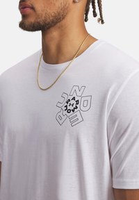 Λευκό βαμβακερό T-shirt με μαύρο γεωμετρικό γραφικό σχέδιο στο αριστερό στήθος και στρογγυλή λαιμόκοψη. Υφασμα με υφή και άνετη εφαρμογή.