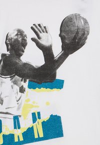 Biały bawełniany T-shirt z czarno-białą grafiką koszykarza w ruchu, z niebieskimi i żółtymi abstrakcyjnymi elementami oraz tekstem.