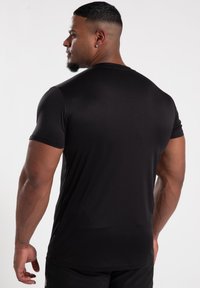 Black short-sleeve athletic shirt made of smooth material, fitted design, with subtle stitching details and a rounded neckline.