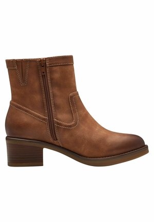Bottine en cuir marron avec un talon large, fermeture éclair sur le côté et détails de couture contrastants. Texture lisse et design à bout rond.