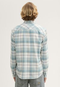 Karierte Hemd mit einem hellblauen, weißen und lila Muster, langen Ärmeln, Knopfmanschetten und einem abgerundeten Saum. Hergestellt aus weichem Stoff.