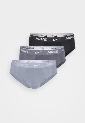 Kolm paari aluspesu mustas, tumes hallis ja heledas hallis, igal paaril bränditud elastne vöökoht, millel on Nike logo.