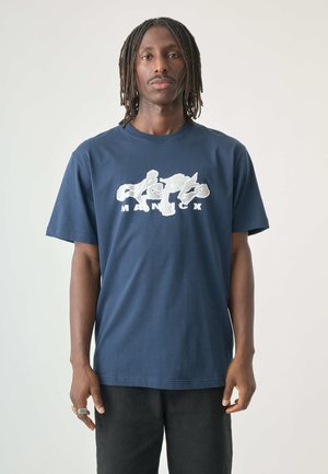 Navy blue cotton t-shirt featuring a large white graphic print with stylized text and shapes, round neckline, and short sleeves.
