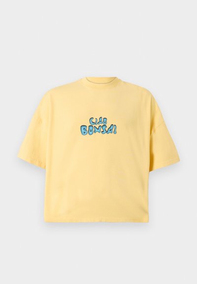 Geel katoenen t-shirt met een losse pasvorm, ronde halslijn en korte mouwen. Heeft een blauwe grafische tekstprint 'Ciao Bonsai' aan de voorkant.