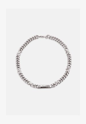 Silberkette mit dicken Gliedern und einem rechteckigen Anhänger mit der Gravur "Ed Hardy" auf weißem Hintergrund.