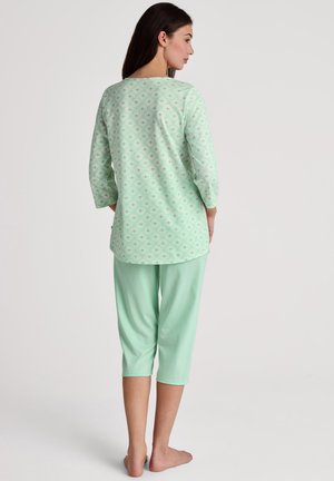 Completo pigiama verde menta composto da una maglietta a maniche lunghe con un motivo geometrico e pantaloni capri, entrambi realizzati in morbido e leggero tessuto di cotone.