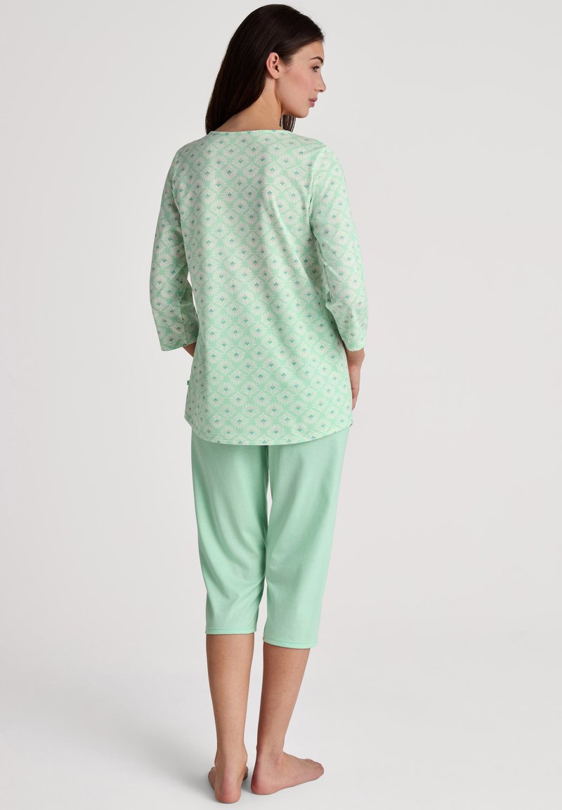 Completo pigiama verde menta composto da una maglietta a maniche lunghe con un motivo geometrico e pantaloni capri, entrambi realizzati in morbido e leggero tessuto di cotone.