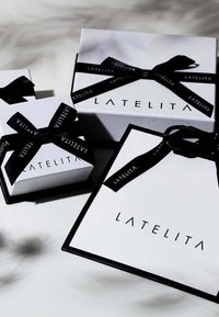 Three rectangular gift boxes in white with black accents and ribbon, featuring the text "LATELITA" on the front. Various sizes displayed.