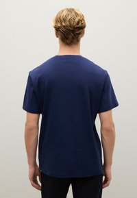 T-shirt in cotone blu navy con scollatura tonda, maniche corte e fit rilassato. Design minimalista, senza loghi o motivi visibili.