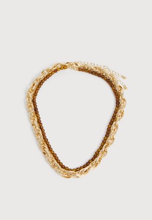 Collier chaîne en or entrelacé avec un rang de petites perles en bois marron, tous deux avec des fermoirs réglables, sur fond blanc.