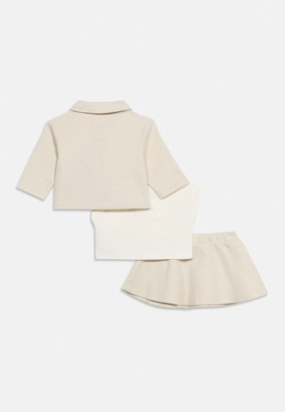 Σετ ρούχων για νήπιο τριών τεμαχίων με μπεζ μακρυμάνικο σακάκι, λευκό κοντομάνικο μπλουζάκι και μπεζ φούστα με φανταζί γραμμή σε λευκό φόντο.