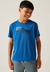 Camiseta azul de manga corta hecha de material sintético, con un gráfico de montaña y sol, texto "LA AVENTURA TE ESPERA", textura suave.