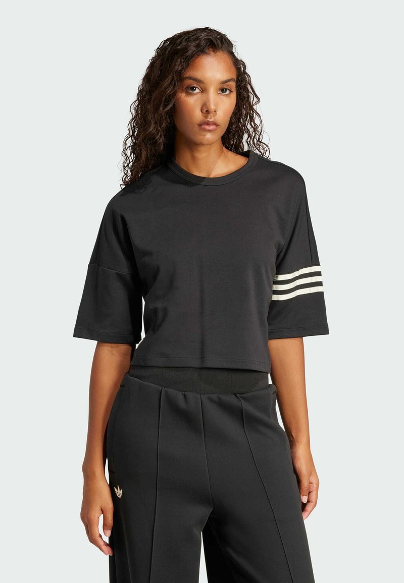 Čierna skrátená tričko s krátkymi rukávmi, s tromi bielymi pruhmi na ľavom ramene. Vyrobené z mäkkej tkaniny, navrhnuté pre pohodlie.