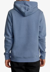 Felpa con cappuccio di colore azzurro chiaro, realizzata in tessuto morbido, con tasca a marsupio e polsini a coste. Dettagli di cucitura visibili sulle cuciture.