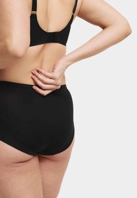 Svart underklädesset med en slät, sömlös design, breda axelband och låg rygg. De höga trosorna erbjuder full täckning.