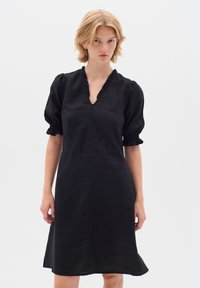 Schwarzes Leinenkleid mit V-Ausschnitt und gerafften Puffärmeln. Verfügt über einen strukturierten Stoff und einen ausgestellten Saum. Einfaches, elegantes Design.