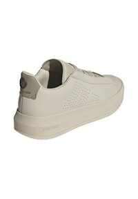 Ljusbeige sneakers med en slät läderöverdel, perforerade detaljer, en tjock dämpad sula och en logotypdetalj på hälen.