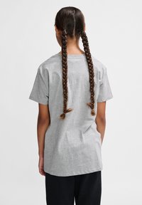 Tricou din bumbac gri cu mâneci scurte, croială lejeră și guler rotund. Spatele prezintă două accente de păr împletit lung.