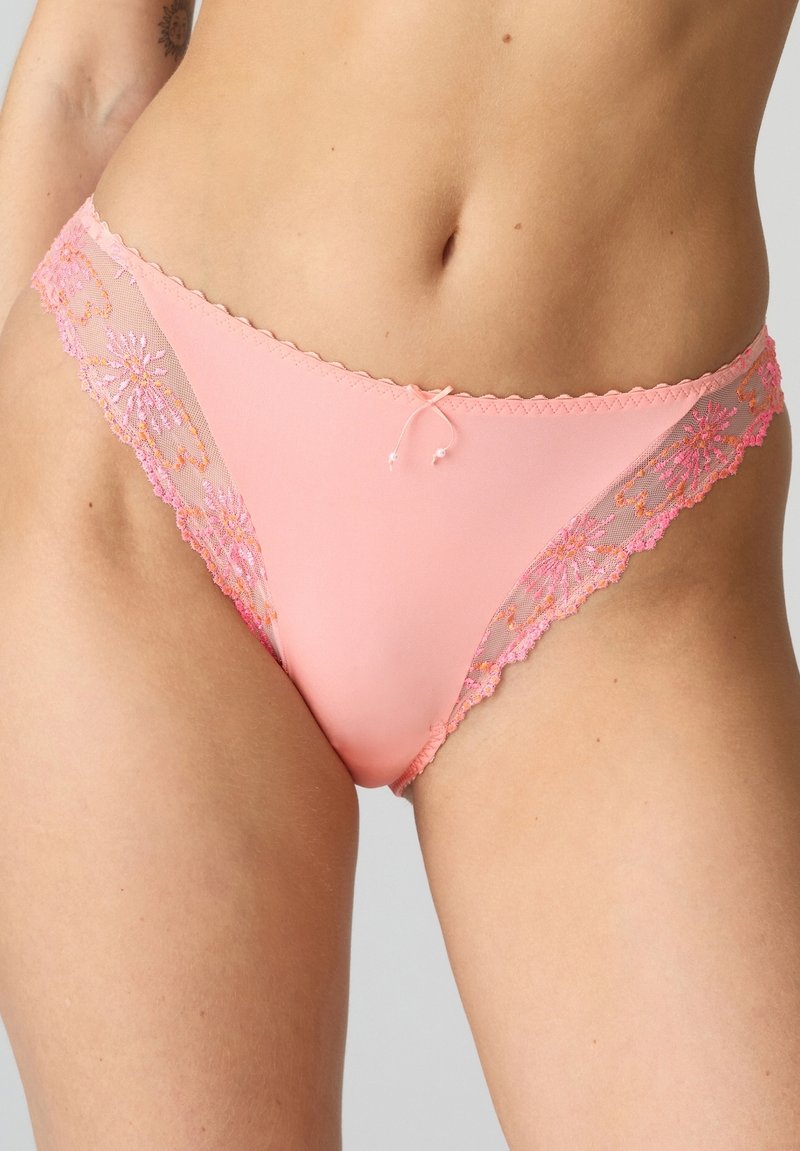 Rosa tygbikini underkläder med genomskinliga spetskanter som har blommönster i rosa och orange nyanser. Sömdetaljer längs kanterna.