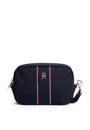 Marineblauwe rechthoekige crossbodytas met rode en witte verticale strepen en gouden logo in het midden, voorzien van een afneembare riem met gouden gesp.