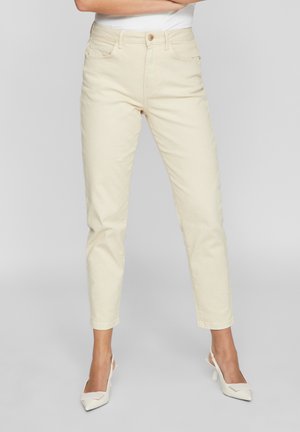 Jeans de cintura alta color crema con silueta ajustada, cinco bolsillos y un ligero ajuste en el tobillo. Tela de algodón suave.