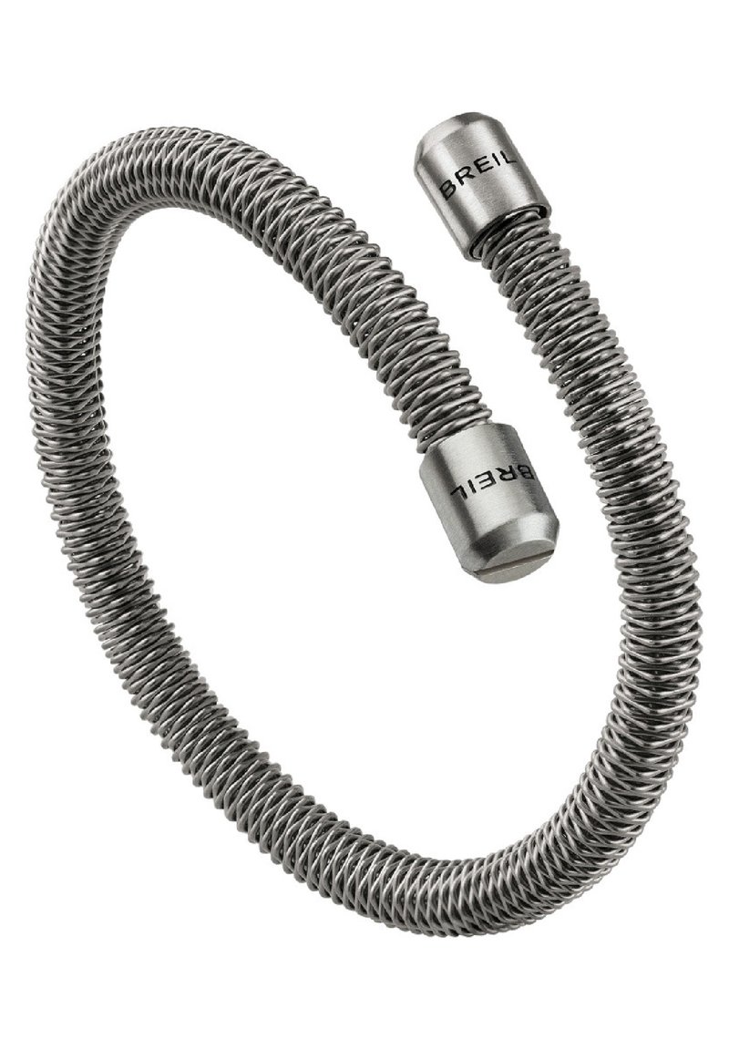 Elastický náramek vyrobený z ohebného kovového drátu, s leštěným stříbrným povrchem a cylindrickými konci s vyrytým názvem značky.