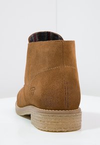 Lichte suède enkelboot met een zachte textuur, iets afgeronde vorm en een patroon in de binnenvoering. Heeft een robuuste rubberen zool.