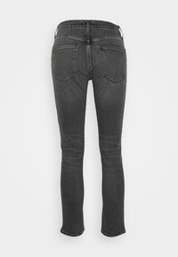 Jeans skinny noirs en denim, avec une taille mi-haute, deux poches arrière et une texture lisse. Les jambes se rétrécissent jusqu'aux chevilles.
