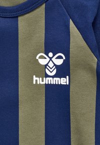 Blau- und olivgrün gestreifter Stoff mit einer weichen Textur. Enthält ein weißes Logo mit stilisierten Flügeln und dem Text "hummel" darunter.